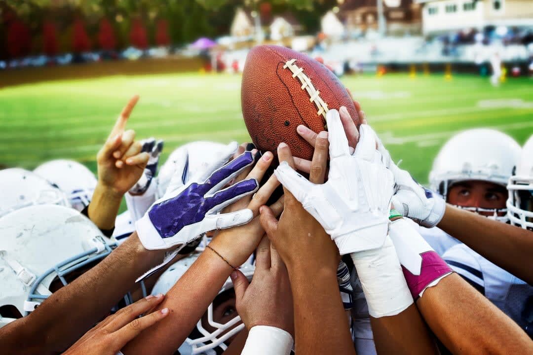 Football players huddled together before a play